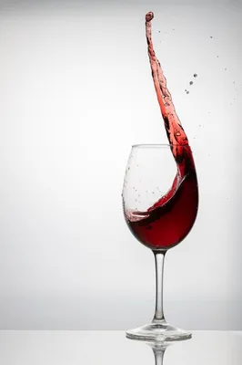 Фотография бокала вина в руке на фоне красивого интерьера