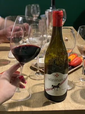 Наслаждение вином: бокал вина в руке на фото