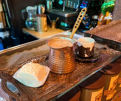 Фото Чашка кофе на блюдце и ромашки в вазочке на подоконнике окна