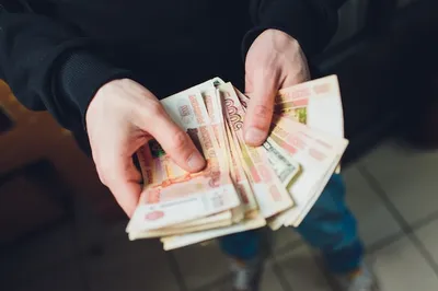 Фото рук, держащих деньги в рублях на белом фоне