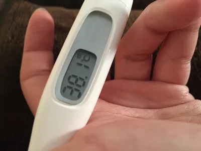 Снимок градусника с определением температуры тела в руке
