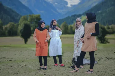 Две Молодые Мусульманские Девушки В Хиджабе Торчат Язык И Улыбаются Перед  Камерой Изолированы На Серый — стоковые фотографии и другие картинки  Малайзийская этническая группа - iStock