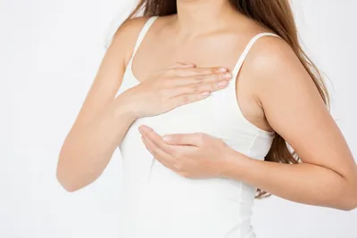Изображение женщины, держащей руки в правильной позе при сцеживании грудного молока