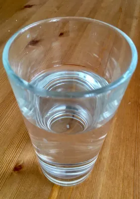 Почему, наливая воду в стакан, часто проливаешь её на стол?