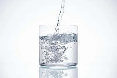 Вода льется в переполненный стакан воды Stock Photo | Adobe Stock