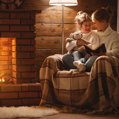 Счастливая семья сидит вместе в уютном доме вечером Стоковое Фото -  изображение насчитывающей жить, уютный: 208722798