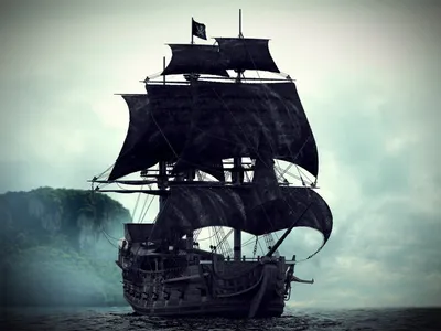 Фото Пиратский корабль с черными парусами стоит у необитаемого острова