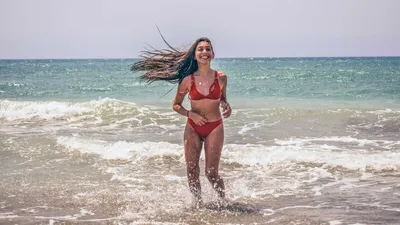 Красивая загорелая девушка брюнетка летом на пляже в черном купальнике  Stock Photo | Adobe Stock