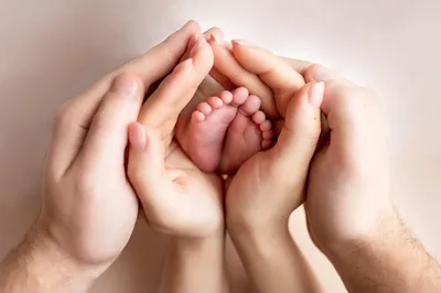 Небольшие ноги новорожденного ребенка в руках мамы и папы, в руках  родителей Стоковое Фото - изображение насчитывающей жизнь, мать: 142688766