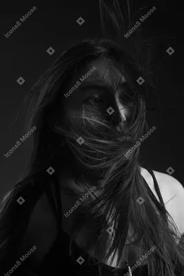 Фото Крупным планом темный силуэт молодой девушки с фейс-артом и  растрепанными волосами, смотрящая в сторону