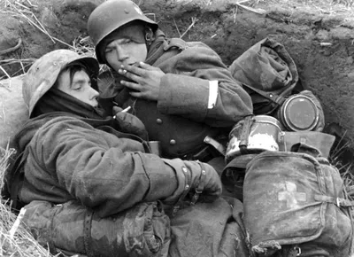Молодые немецкие солдаты курят в окопе — военное фото