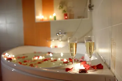 Расслабляющая при свечах ванна с лепестками роз и резиновая утка. Нижний  свет, потому что туалет был освещен со свечами, чтобы соз Стоковое  Изображение - изображение насчитывающей купает, нутряно: 208037515