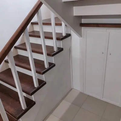 Обшивка бетонной лестницы с пристенными панелями в частном доме с кладовкой  и подсветкой