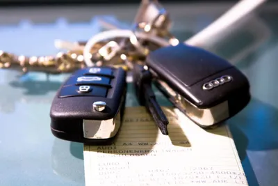 Ключи от машины в руке на фоне зелени