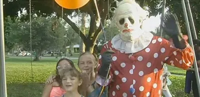 Клоун убийца с куклой на фото
