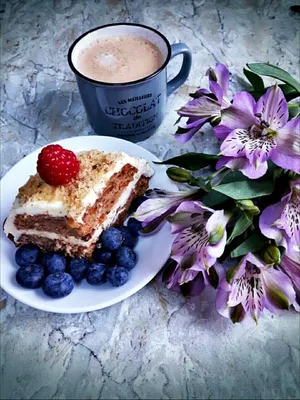 День Святого Валентина.Пирожное на белой тарелке, украшенное сердечками и  чашка кофе на столе. Photos | Adobe Stock