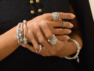 Кольца Пандоры на руке на фоне красивых ногтей