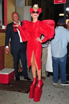 Гламурная дама в красном платье позирует перед камерой на фоне студии |  Премиум Фото