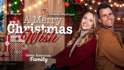 Merry Christmas\" in a cheerful, bubbly font, nestled among a collection of  cute, colorful Christmas baubles, each with smiling faces, against a  backdrop of twinkling holiday lights