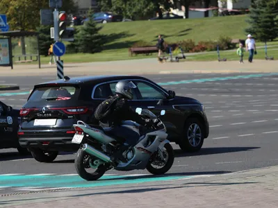 Мотоциклист в кожаном наряде и черном шлеме сидит на дороге рядом со  спортом на велосипеде Стоковое Фото - изображение насчитывающей  конкуренция, сила: 211870732