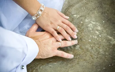 Мужская рука с обручальным кольцом на фоне морского пейзажа
