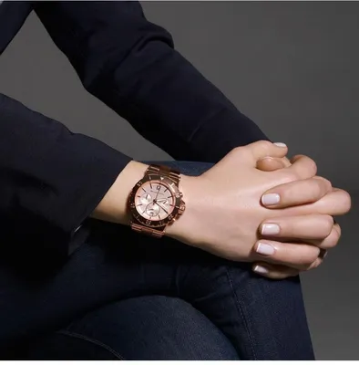 Изображение женской руки с мужскими часами на черном фоне