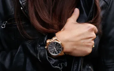 Картинка мужских часов на женской руке с золотым циферблатом