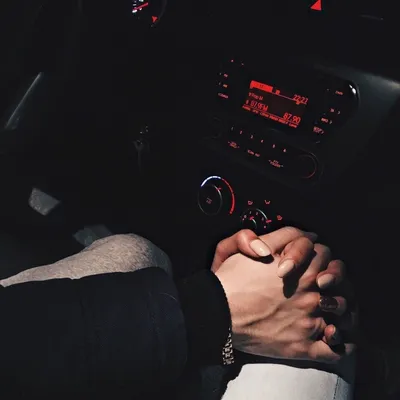 Сильная рука мужчины, нежная рука женщины в машине