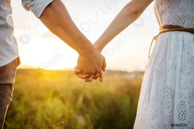 Романтическая фотография пары, держащейся за руки