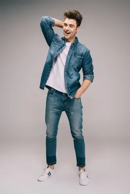 Задумчивый парень в джинсах с обнаженным мускулистым торсом стоит,  прислонившись плечом к стене | Премиум Фото