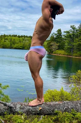 мускулистый молодой красавчик-сексуальный мокрый парень с спортивным телом,  позирующий в красные плавательные стволы рядом с камне Стоковое Изображение  - изображение насчитывающей горяче, персона: 244573507