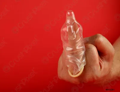 Рука, держащая презерватив: эротическое фото