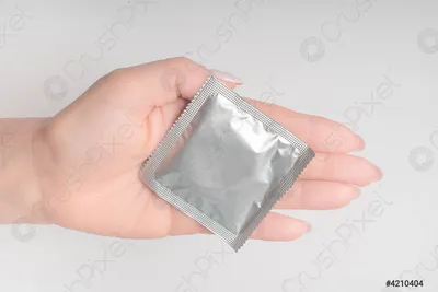 Презерватив в руке: крупный план