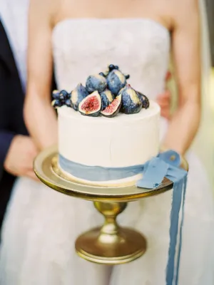 Изображение рук молодоженов с кольцами на фоне свадебного букета