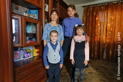 Young happy family at Christmas tree/ Not father, mother and little boy and  two girls. Молодая семья, без отца мама, трое детей, мальчик и две девочки.  Stock Photo | Adobe Stock