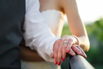 Фотография свадебных рук с кольцами на фоне водопада