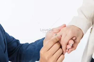 Фотография свадебных рук с кольцами на фоне красивого здания