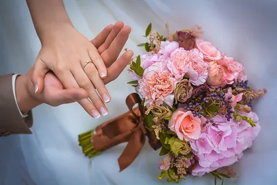 Свадебные руки с кольцами на фоне заката