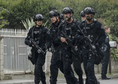 Member of the SWAT squad with an assault rifle in a black uniform on blue  background. Special weapons and tactics. Special Forces. Stock Photo |  Adobe Stock