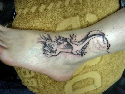 Изображение татуировки ящерицы на руке в реалистичном стиле