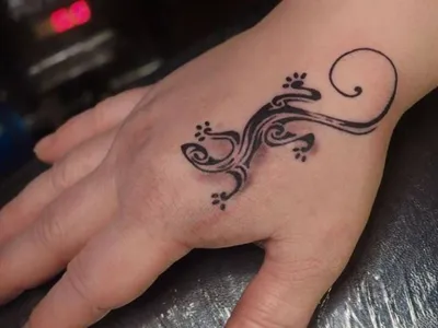 Изображение татуировки ящерицы на руке с использованием ярких цветов