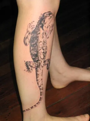 Изображение татуировки ящерицы на руке в стиле абстракции