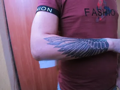 Фото тату крылья на руке в стиле трибал