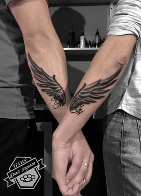 Фото татуировки крылья на руке на закате