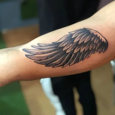 Картинка тату крылья на руке на темном фоне