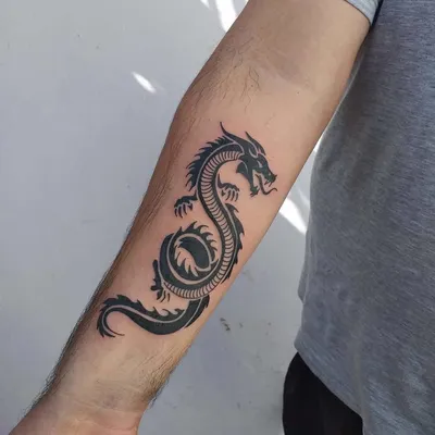 Фотография тату на руке дракона с цветочными элементами