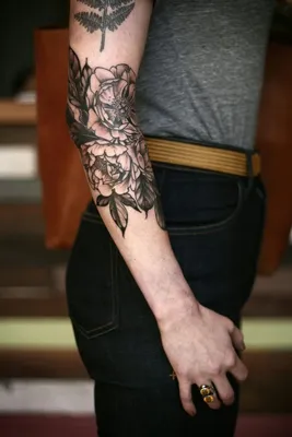 Фото татуировки на сгибе руки на тёмном фоне