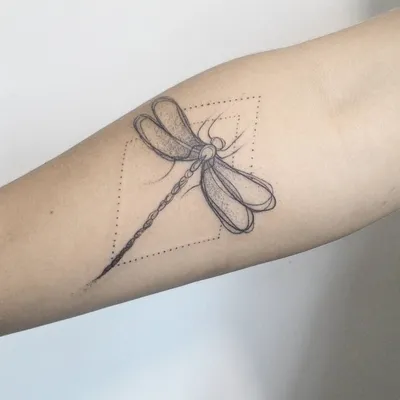 Фото татуировки стрекозы на руке: изображение в стиле линейной графики