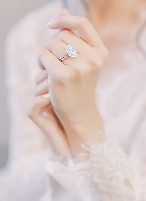 Фото женской руки с кольцом на белом фоне