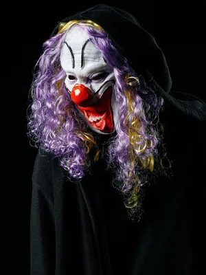 Фотография злого клоуна на фоне циркового шатра
